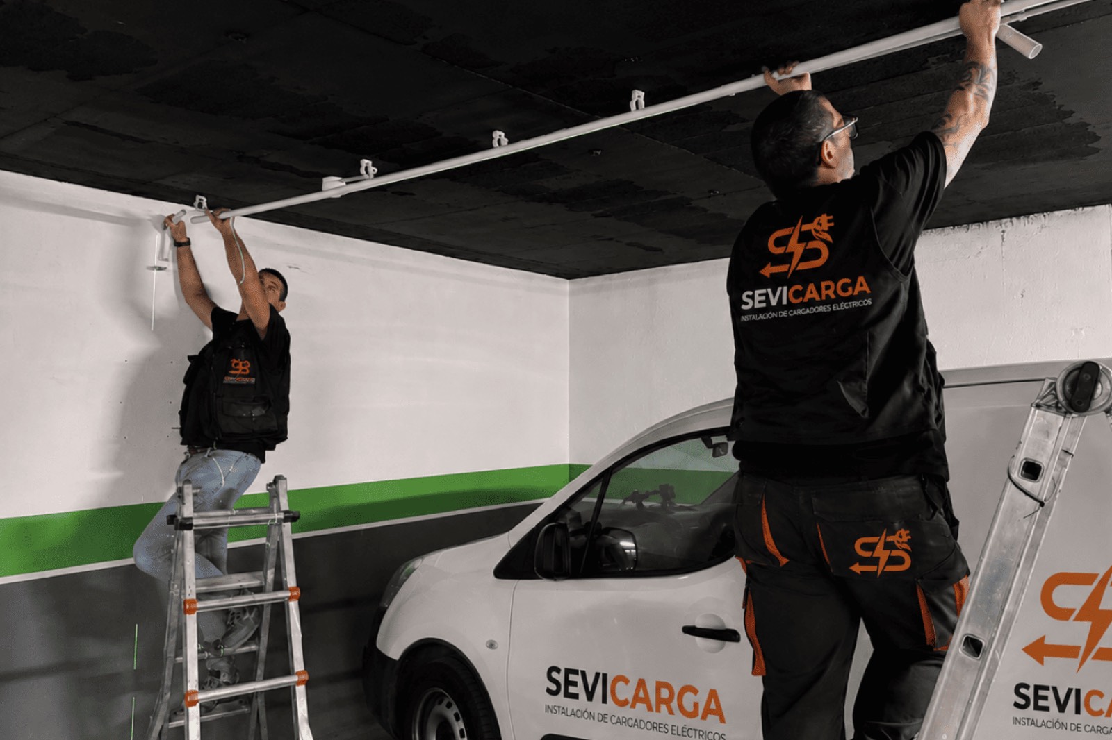 Instaladores de Sevicarga montando la canalización de un cargador de coche eléctrico en un garaje de Sevilla
